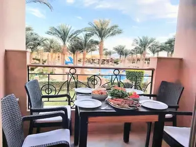 a table with a plate of food on a balcony at JWE Residence - Quality experience near Red Sea in Hurghada