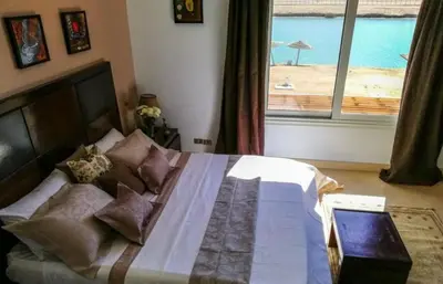 a bedroom with a bed with a view of a beach at Babel Apartments Hotel El Gouna in Hurghada