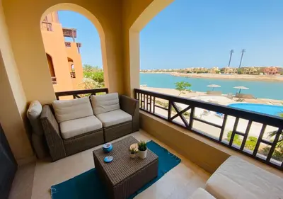 a living room with a couch and a balcony with a view at Babel Apartments Hotel El Gouna in Hurghada