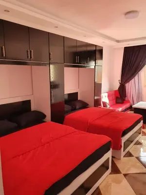 two beds in a room with red sheets at sheraton blaza307 in Hurghada