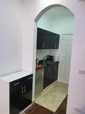 a kitchen with black cabinets and a white counter top at sheraton blaza307 in Hurghada