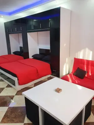 a bedroom with a red bed and a couch at sheraton blaza307 in Hurghada