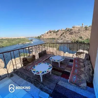 a balcony with two tables and a view of the water at Belle Vue Sur Le Nile بيت هاني in Aswan