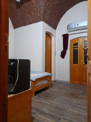 a room with a bed and a tv in it at Belle Vue Sur Le Nile بيت هاني in Aswan