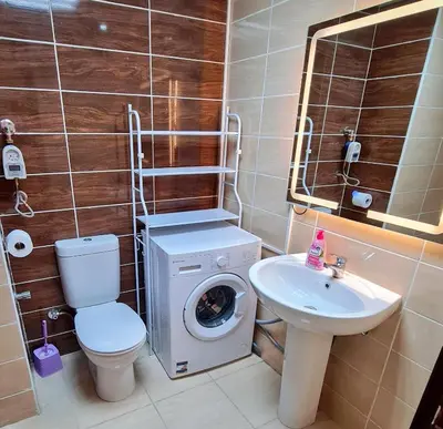 a bathroom with a washing machine and a sink at Florenza Blue Sky & Poolview Studio Hurghada in Hurghada