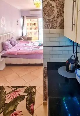 two images of a room with a bed and a kitchen at Florenza Blue Sky & Poolview Studio Hurghada in Hurghada