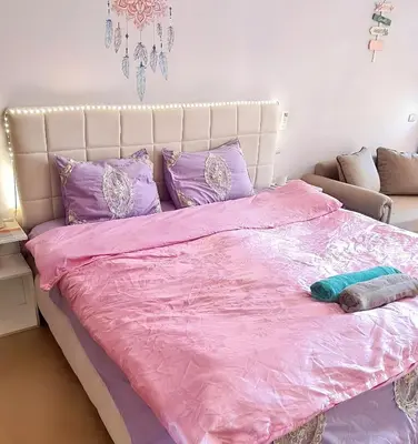a bedroom with a pink bed with purple pillows at Florenza Blue Sky & Poolview Studio Hurghada in Hurghada