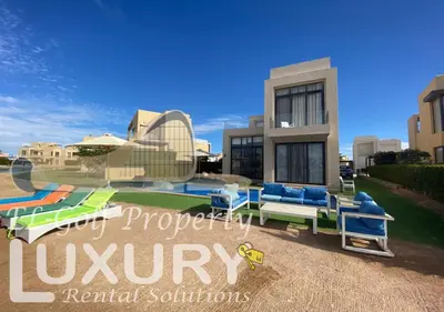 a villa with a swimming pool in front of a house at Tawila Villa T1-15 in Hurghada