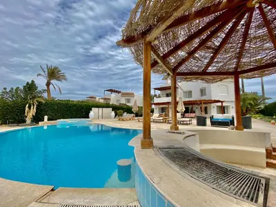 a large swimming pool with a large umbrella at Villa 9 ph-5 with 4 Bed Room in Hurghada
