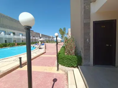 a couple of street lights next to a pool at Cecilia Resort Chalets- Hurghada in Hurghada