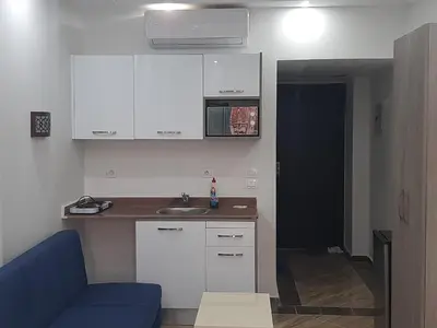 a kitchen with white cabinets and a blue couch at Cecilia Resort Chalets- Hurghada in Hurghada