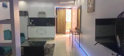 a kitchen with white cabinets and a tv in a room at The view studio in Hurghada