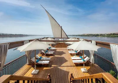 a deck with chairs and umbrellas on a boat at Dahabeya Molouky Nile Cruise- Every Monday from Luxor- Aswan for 05 nights in Luxor
