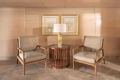 two chairs and a table with a lamp in a room at Jaz Elite Regent Nile Cruise - Every Monday from Luxor for 07 & 04 Nights - Every Friday From Aswan for 03 Nights in Luxor
