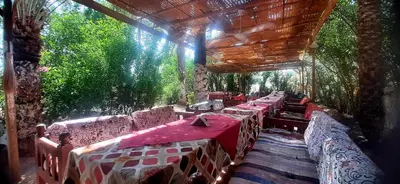 a row of tables in a restaurant with red table cloth at Nour El Gourna in Luxor