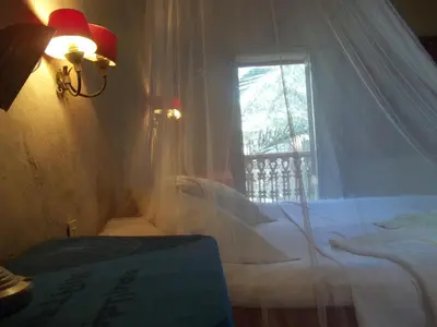 a bedroom with a bed and a window with curtains at Nour El Gourna in Luxor