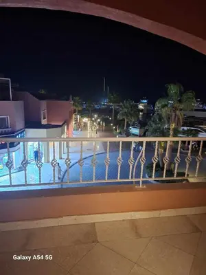 a balcony with a view of a city at night at Marena Hurghada in Hurghada