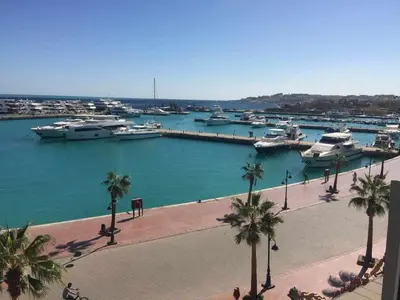 a marina with boats in the water and palm trees at Marena Hurghada in Hurghada