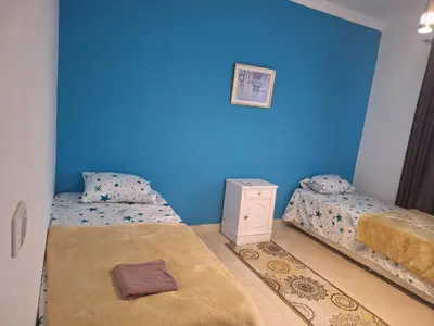 two beds in a room with a blue wall at new marina heart of Hurghada in Hurghada