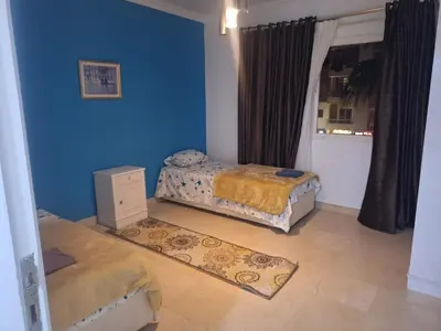 a bedroom with two beds and a blue wall at new marina heart of Hurghada in Hurghada