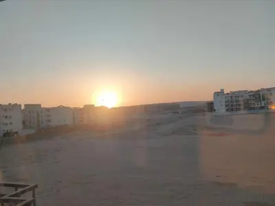 a view of the sunset from a parking lot at la vi -panorama sea in Hurghada
