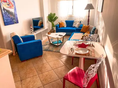a living room with a couch and a table and chairs at Modern Mountain View on The Touristic Promenade in Hurghada