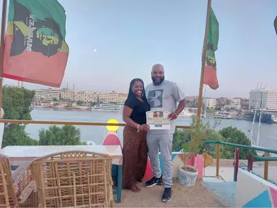 a man and a woman holding up a box at One Love Guesthouse & Restaurant in Luxor