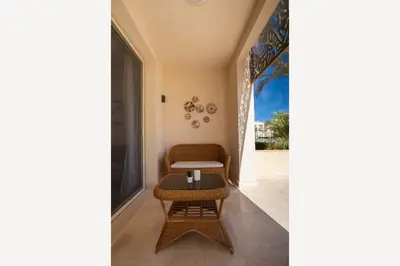 a living room with a chair and a table at Jazzy 1BDR w Outdoor Pool View Terrace Free Pool & Beach Access in Hurghada