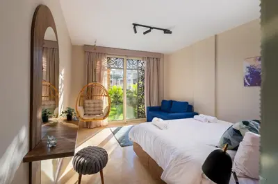 a bedroom with a bed and a chair and a window at Elegant & Edgy 2 BR w Beach & Pool Mangroovy in Hurghada