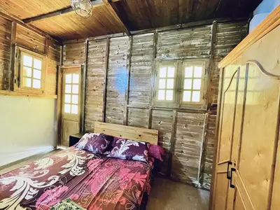 a bedroom with a bed in a wooden wall at Cozy Apartment in Qadd el-Barûd