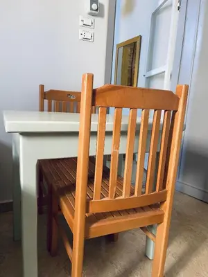 a wooden chair sitting at a table with a white desk at Cozy Apartment in Qadd el-Barûd