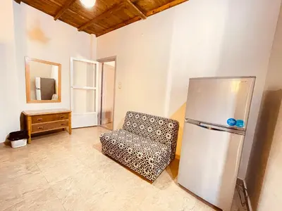 a leopard print chair in a room with a refrigerator at Cozy Apartment in Qadd el-Barûd