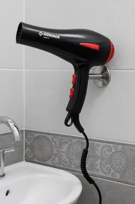a hair dryer hanging from a bathroom sink at Hossam Deluxe Apartment El Hadaba Sheraton in Hurghada