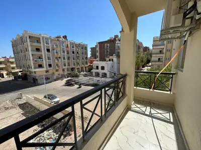 a balcony with a view of a city with buildings at Hossam Deluxe Apartment El Hadaba Sheraton in Hurghada