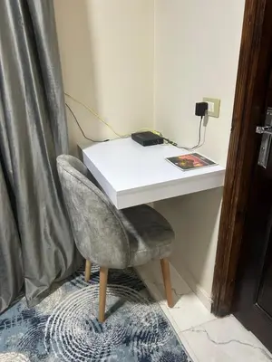a white desk with a chair next to a wall at Hossam Deluxe Apartment El Hadaba Sheraton in Hurghada