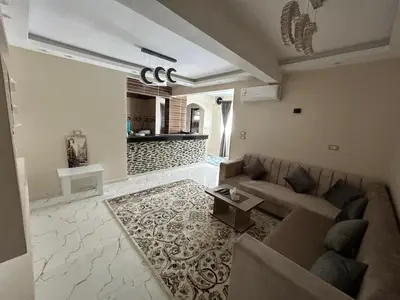 a living room with a couch and a table at Hossam Deluxe Apartment El Hadaba Sheraton in Hurghada