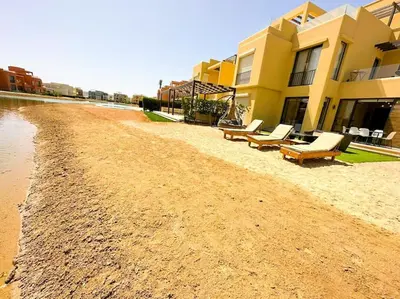 a row of benches on a beach next to a building at Luxury 3 bedrooms town house in Hurghada