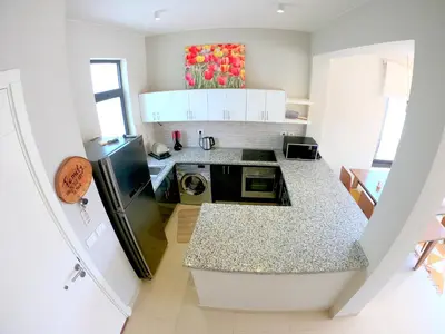 a kitchen with white cabinets and a black refrigerator at Luxury 3 bedrooms town house in Hurghada