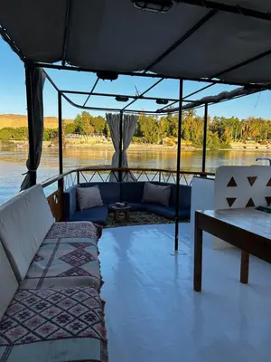 a boat with couches and a table on the water at Houseboat Hotel and Nile Cruises Zainoba in Aswan