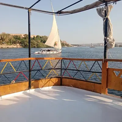 a boat on the water with a sailboat in the water at Houseboat Hotel and Nile Cruises Zainoba in Aswan