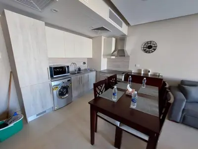 a living room with a table and a kitchen at MCJ Luxury 2 Bedrooms Apartment in Hurghada