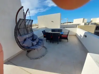 a swing on a balcony with a table and chairs at MCJ Luxury 2 Bedrooms Apartment in Hurghada