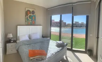 a bedroom with a bed and a large window at Tawila, 4 Bedroom Villa, Brand new, directly on a lagoon in Hurghada