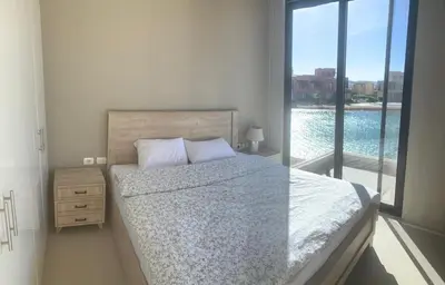 a bedroom with a bed and a view of a pool at Tawila, 4 Bedroom Villa, Brand new, directly on a lagoon in Hurghada