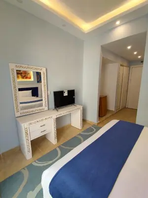 a bedroom with a bed and a desk with a television at La Boutique Residence in Hurghada