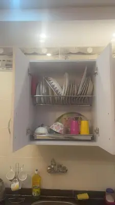 a kitchen sink with plates and dishes on a shelf at Hossam Comfort Apartment El Hadaba Hurghada in Hurghada