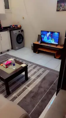 a living room with a flat screen tv and a table at Hossam Comfort Apartment El Hadaba Hurghada in Hurghada