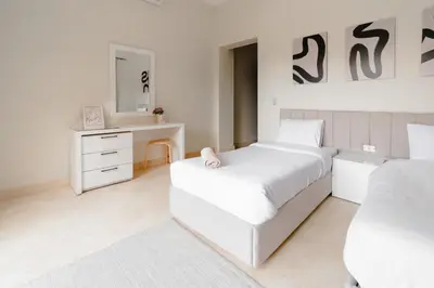 a white bedroom with two beds and a dresser at Modern Villa in El Gouna (Private Pool & Garden.) in Hurghada
