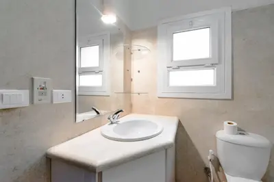 a bathroom with a sink and a mirror and a toilet at Modern Villa in El Gouna (Private Pool & Garden.) in Hurghada
