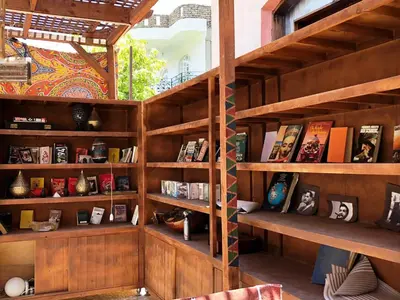 a library with wooden shelves filled with books at Nile Compound in Luxor